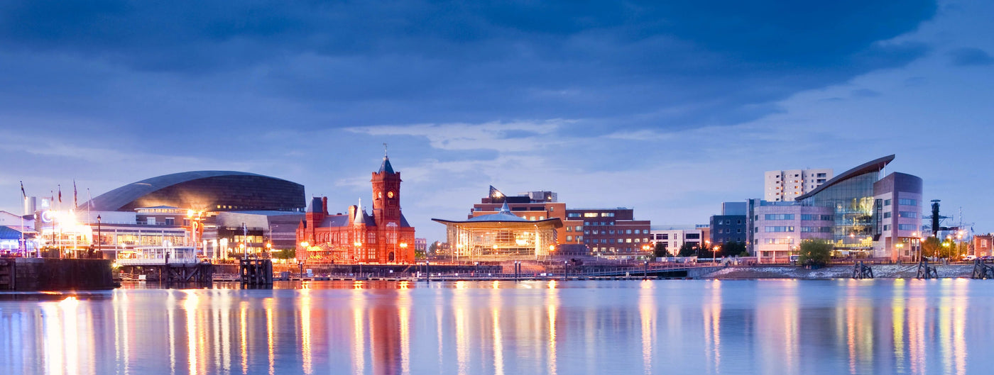Cityscape at night with illuminated buildings reflected in water